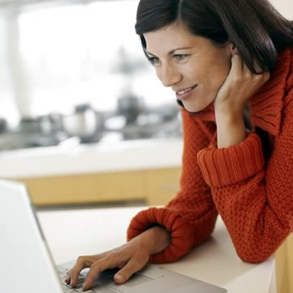 A photo of a woman looking at a laptop computer
